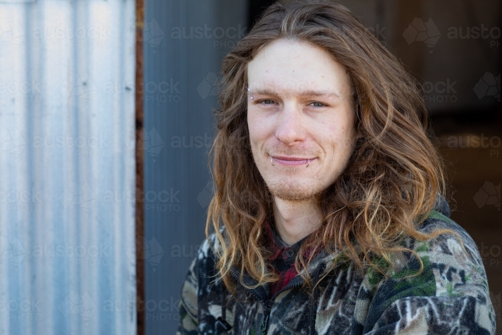 long-haired young man with lip piercings - Australian Stock Image