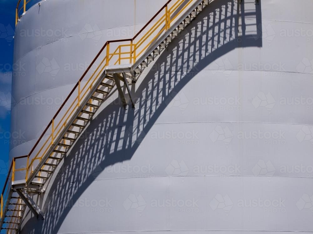Long shadows of stairs up the side of a large tank - Australian Stock Image