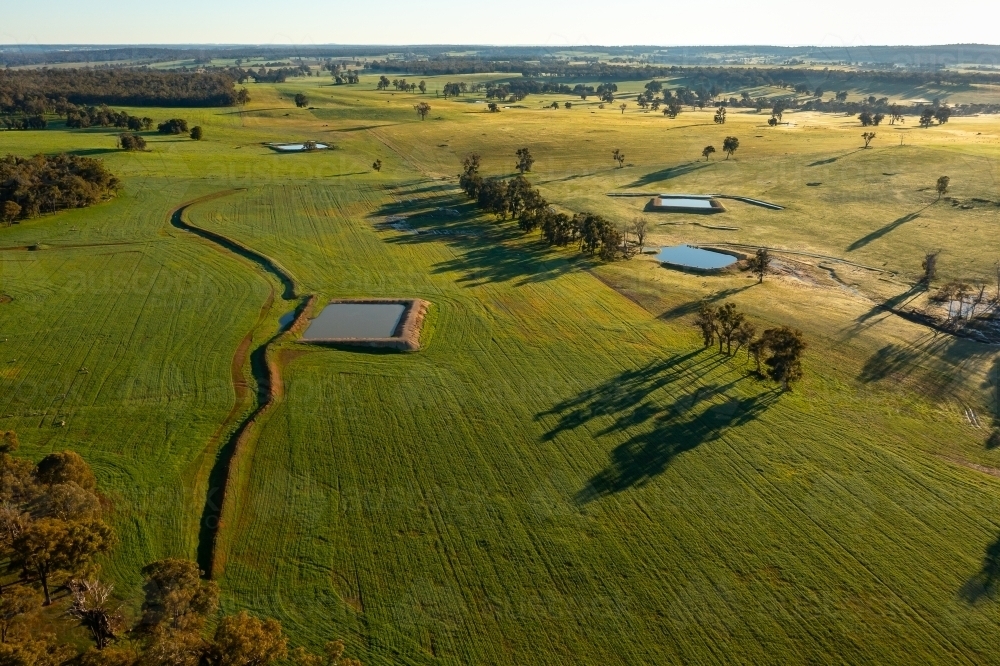 long shadows over farmland with crops and dams - Australian Stock Image