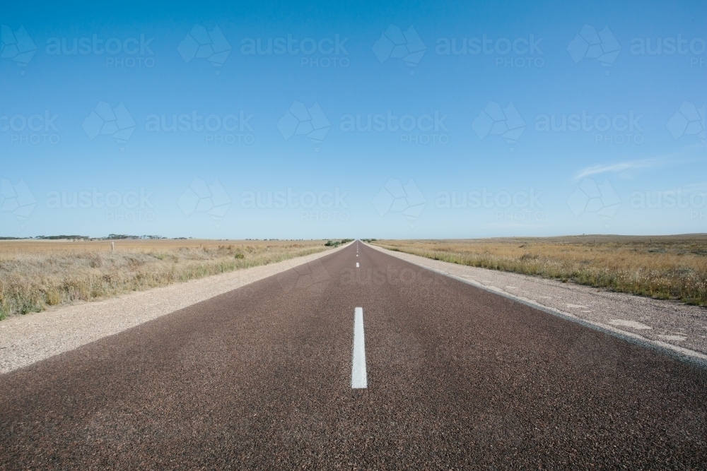 Long straight empty road through rural land - Australian Stock Image