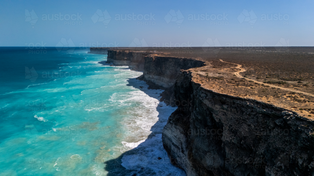 Long stretch of towering cliffs with deep turquoise waters. - Australian Stock Image