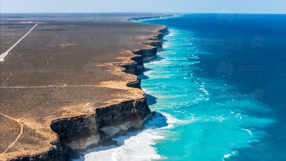 Long stretch of towering cliffs with deep turquoise waters. - Australian Stock Image