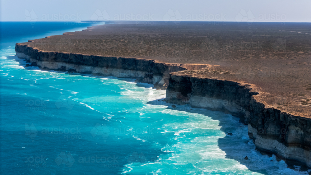 Long stretch of towering cliffs with deep turquoise waters. - Australian Stock Image