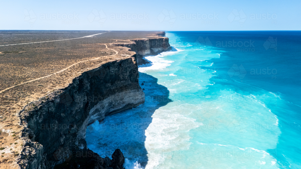 Long stretch of towering cliffs with deep turquoise waters. - Australian Stock Image