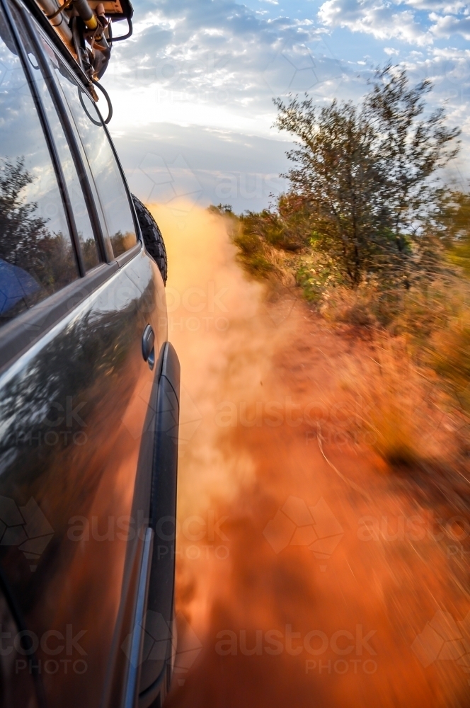look back at dust while driving on a dirt road - Australian Stock Image