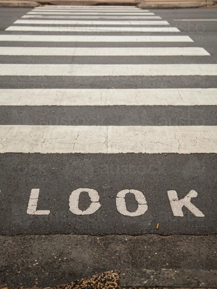 Look sign before black and white pedestrian crossing on road - Australian Stock Image