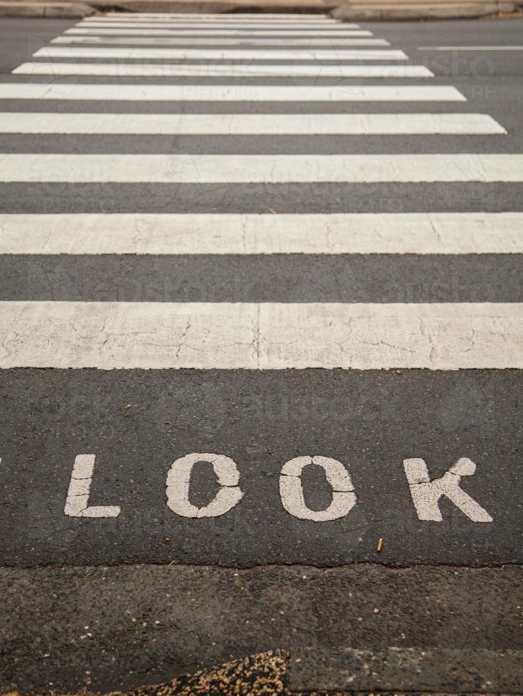 Look sign before black and white pedestrian crossing on road - Australian Stock Image