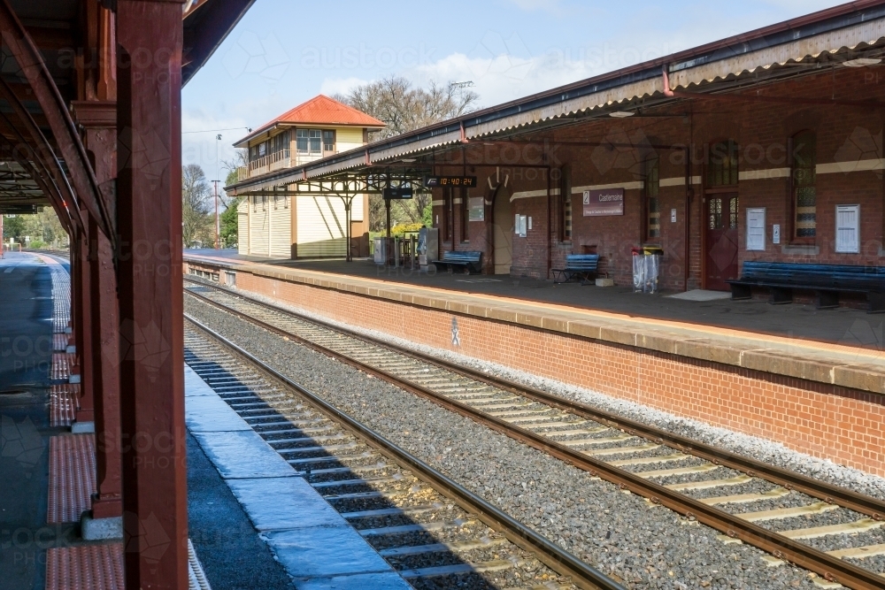 Looking a long the edge of an empty railway platform of a rural railway station - Australian Stock Image