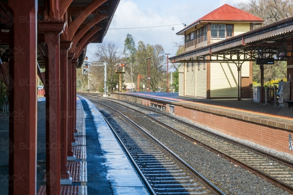 Looking a long the edge of an empty railway platform of a rural railway station - Australian Stock Image