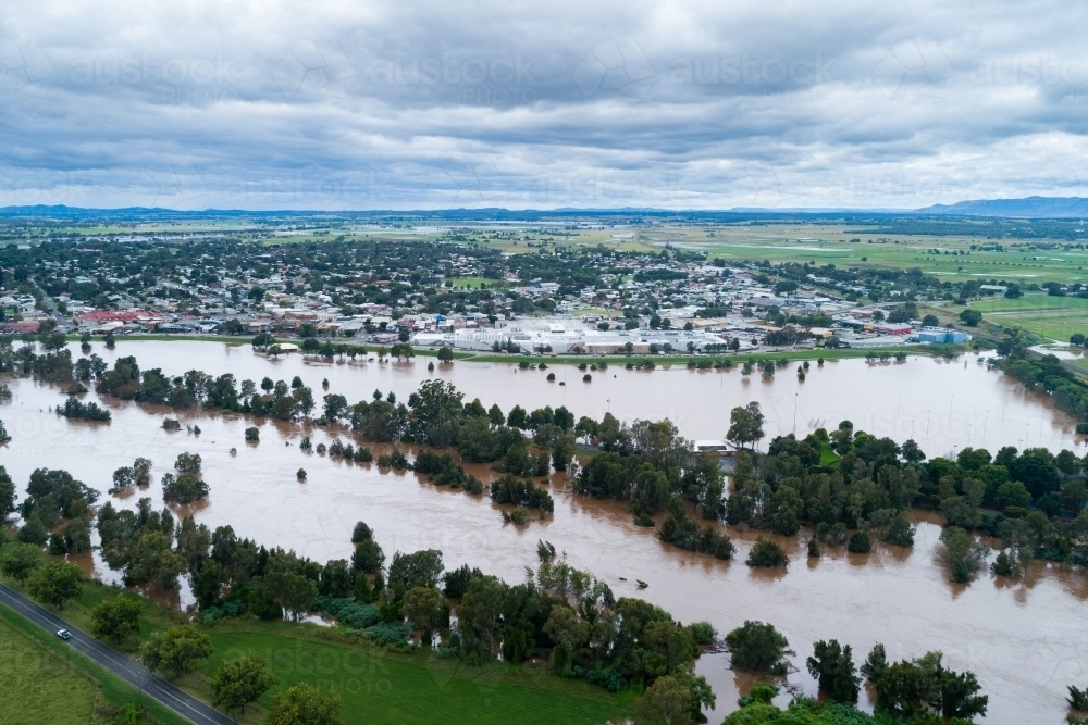 Looking across flooding Hunter River towards the levee bank and singleton town - Australian Stock Image