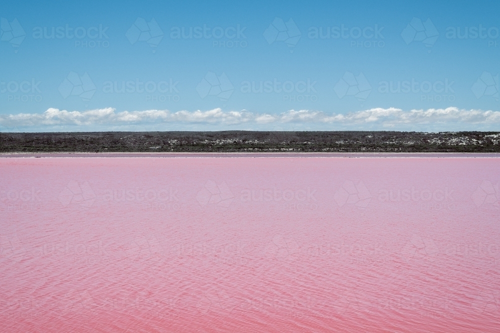 Looking across Pink Lake Lagoon with low hills in the distance - Australian Stock Image