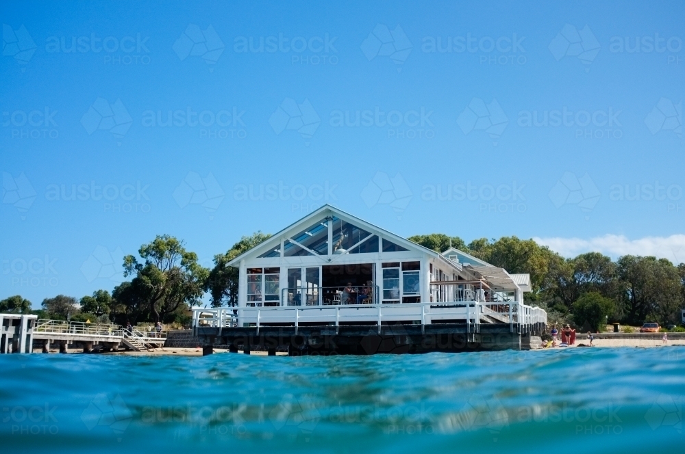 Looking across water to a wharf restaurant. - Australian Stock Image
