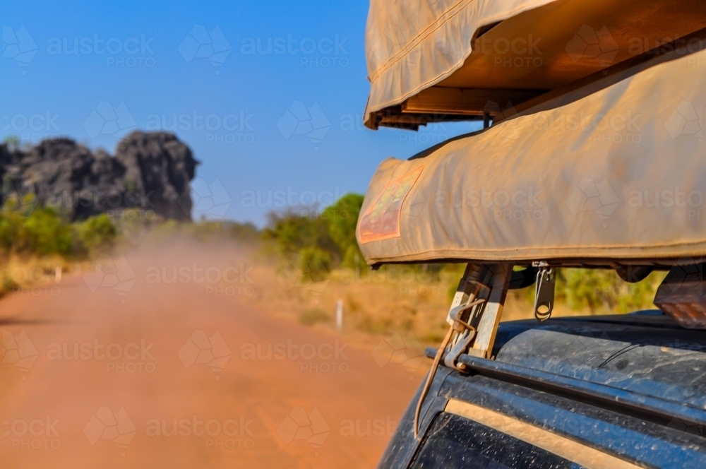 looking back on a dirt road with dust on car - Australian Stock Image