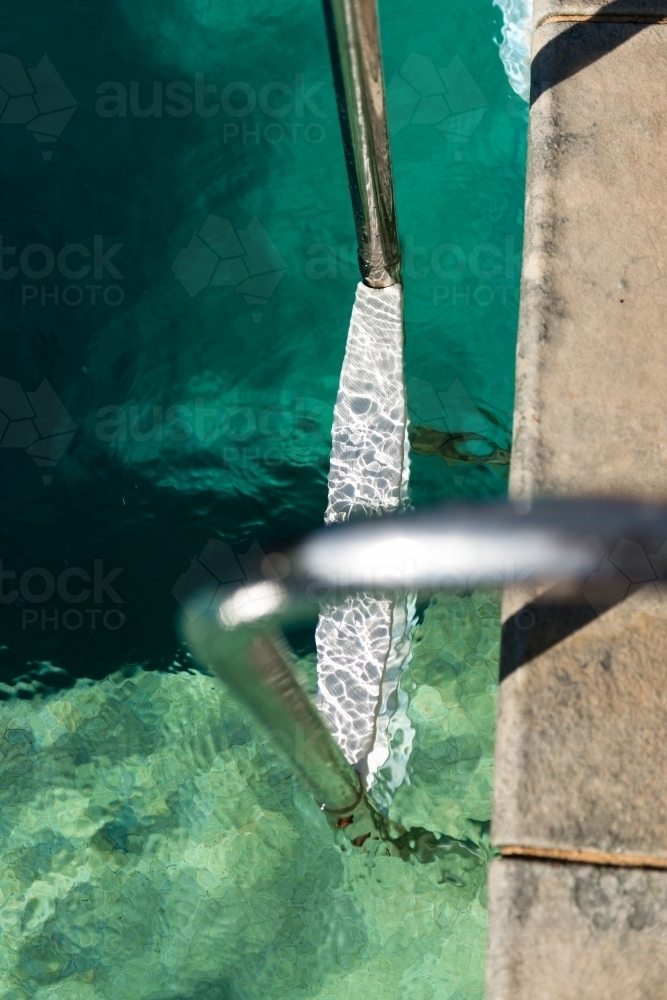 looking down at a ladder in a swimming pool - Australian Stock Image