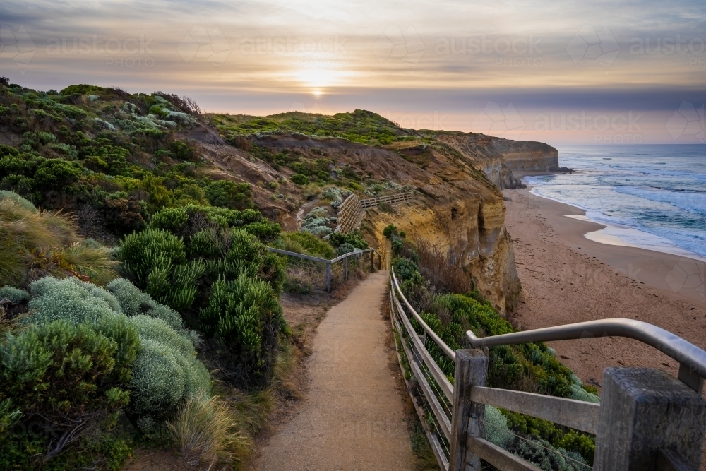 Looking down coastal walking track towards the sunrise and the beach below - Australian Stock Image