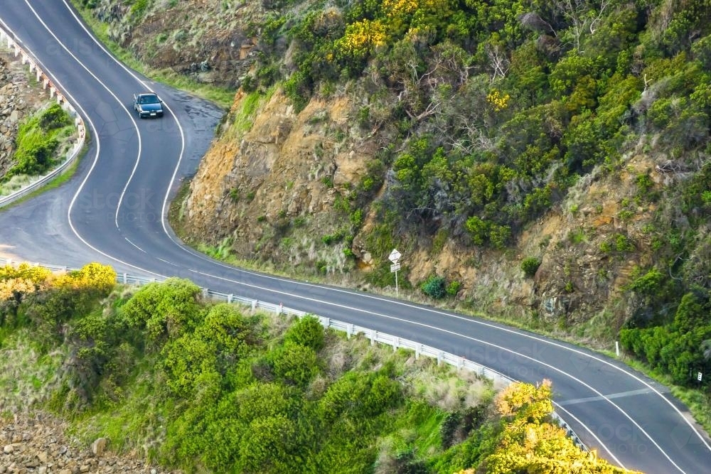 Image of Looking down on a car driving on a winding road Image of Looking down on a car driving on a winding road