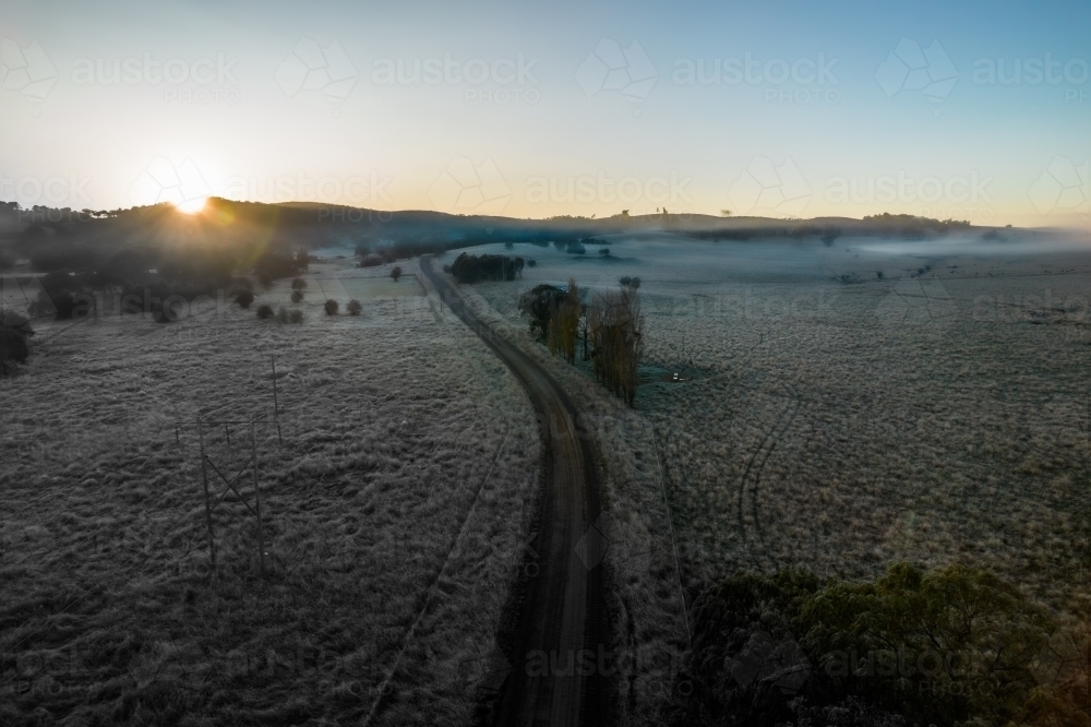 Looking down on a frosty morning the country side with a road leading into the distance - Australian Stock Image