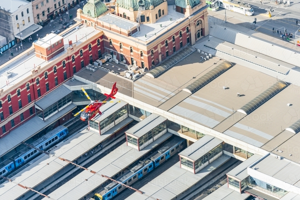 Looking down on a helicopter flying over Flinders Street Railway Station - Australian Stock Image