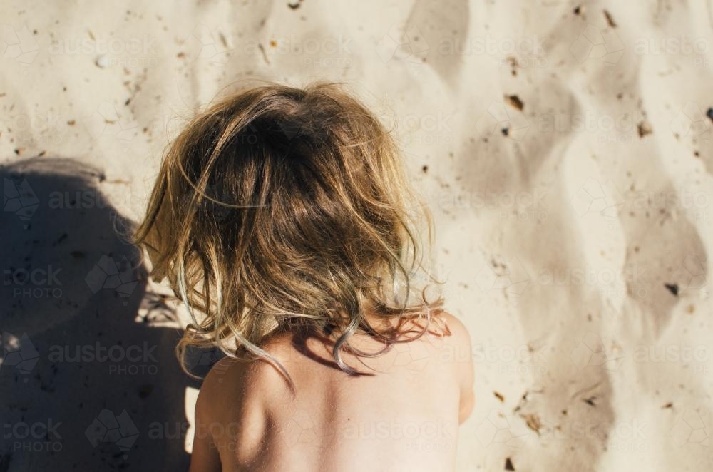 Looking down on a small child playing at the beach - Australian Stock Image