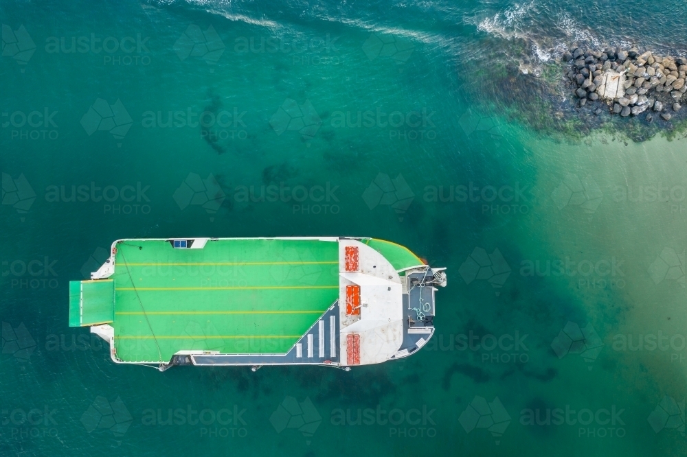 Looking down on an empty car ferry anchored near a breakwater - Australian Stock Image