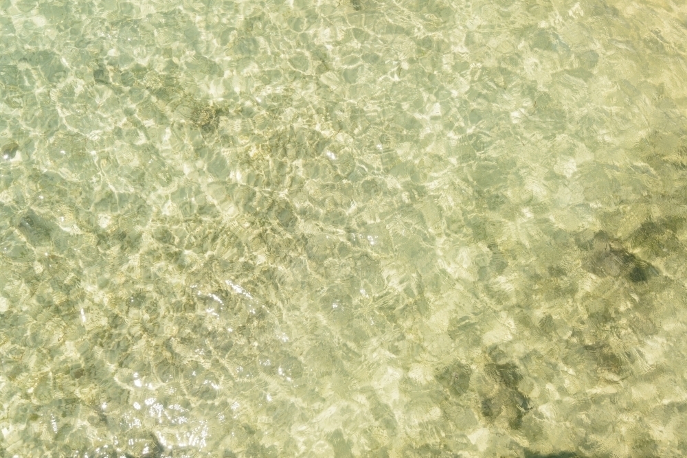 Looking down on clear water rippling over sand - Australian Stock Image