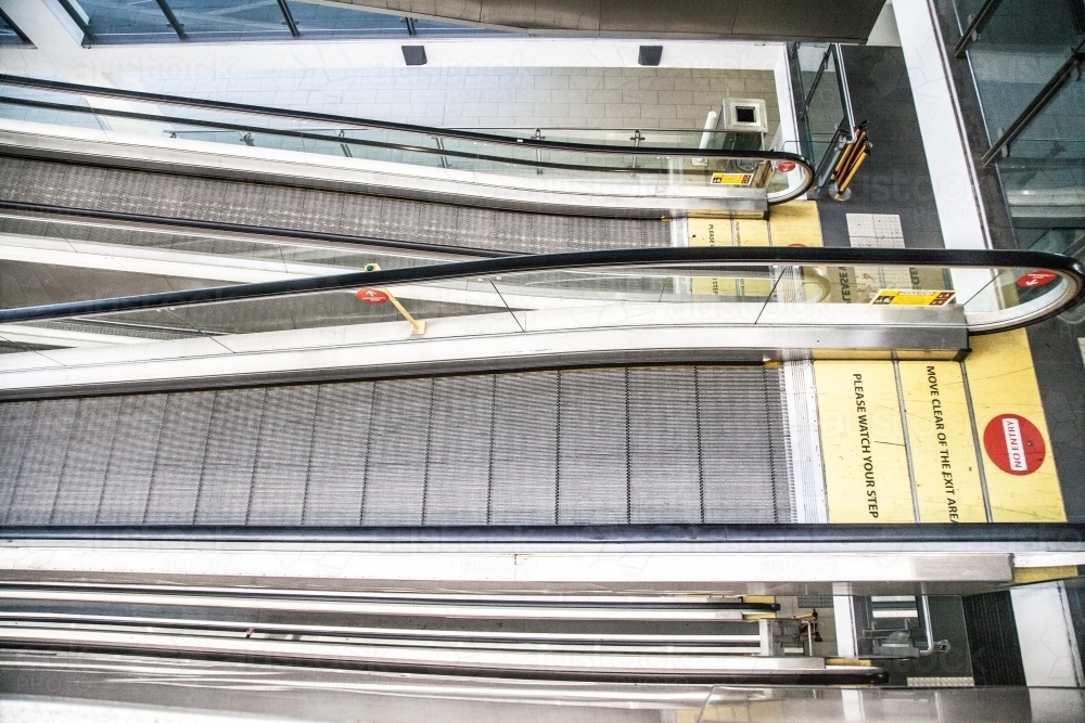 Looking down on layers of escalator going up and down - Australian Stock Image