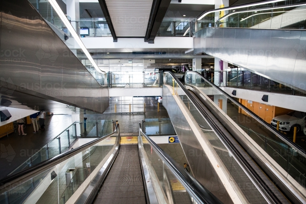 Looking down on layers of escalator going up and down - Australian Stock Image