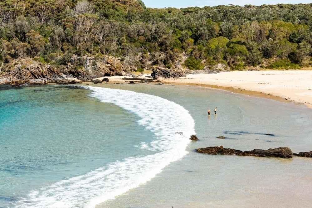 Looking down on picturesque cove and beach with people - Australian Stock Image