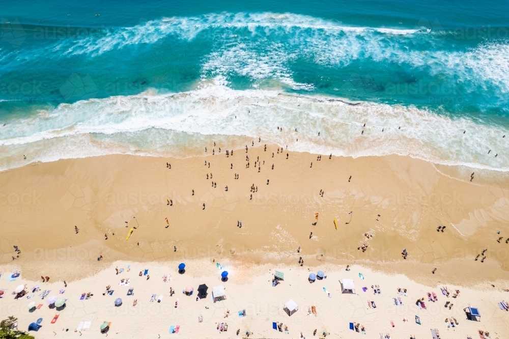 Looking down on swimmers going out to the water from the shoreline - Australian Stock Image