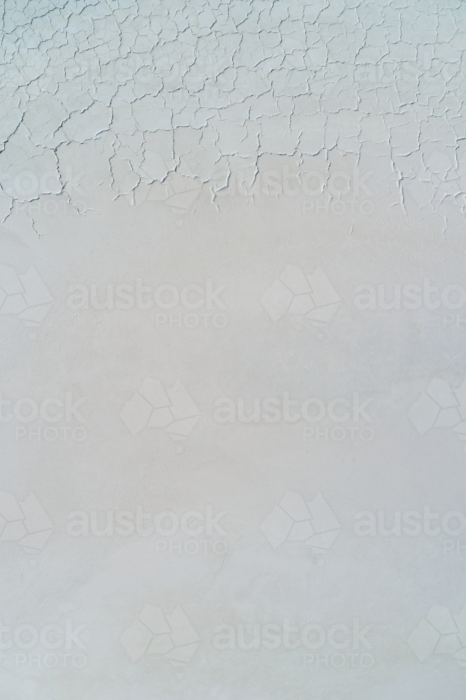 Looking down on the pattern and texture of cracks on the surface of a dry salt lake. - Australian Stock Image