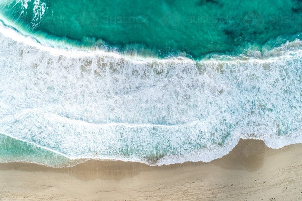 Looking down on waves crashing onto beach. - Australian Stock Image
