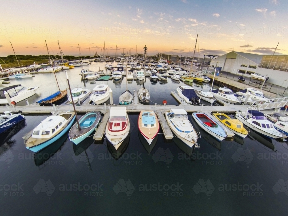 Looking down over yachts and boats in a marina at sunrise. - Australian Stock Image