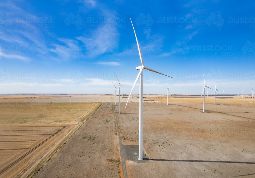 Looking down the line of wind turbines in a wind farm - Australian Stock Image
