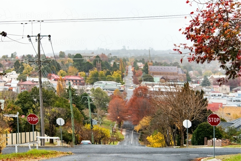Looking down the street surrounded by red autumn trees in small country town - Australian Stock Image