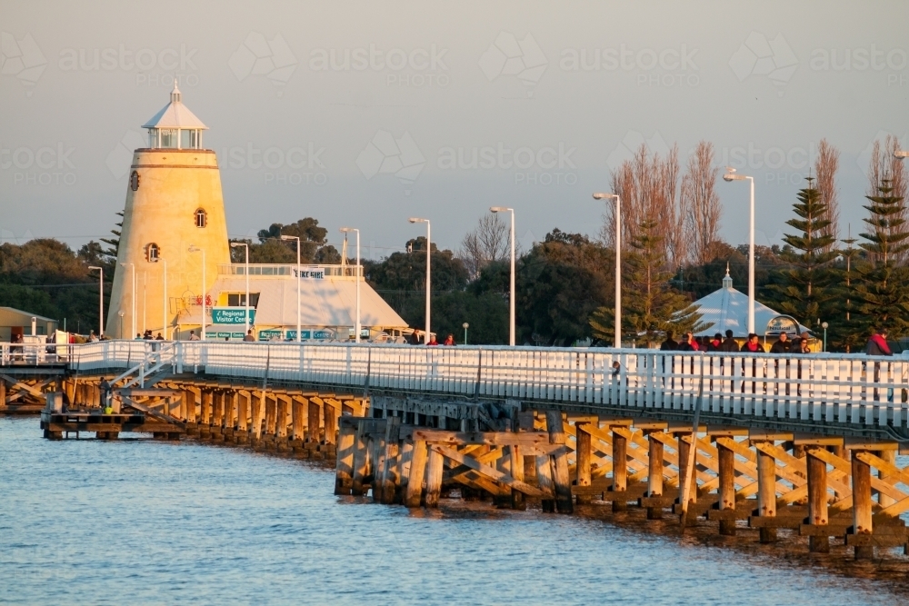 Looking inland along a fenced jetty at a mock lighthouse - Australian Stock Image