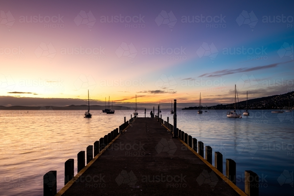 Looking out along a wharf to a sunset - Australian Stock Image