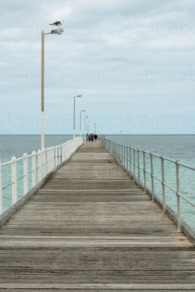 Looking out along a wharf with people at the end of the wharf - Australian Stock Image