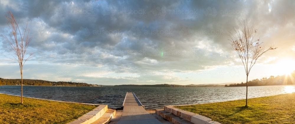 Looking out over jetty and sunlit water of Lake Macquarie at Warners Bay - Australian Stock Image