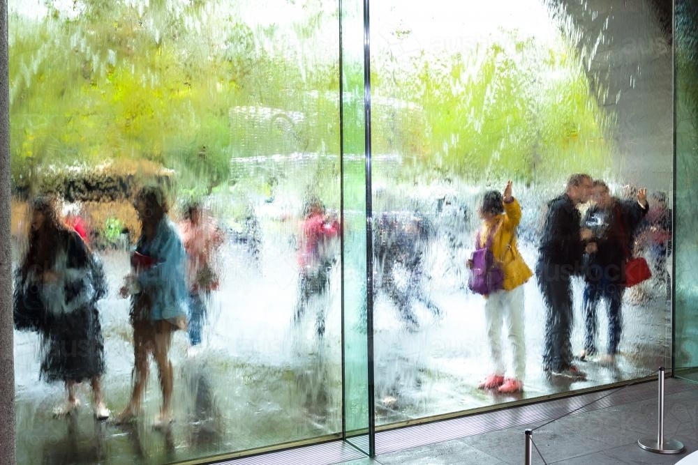 Looking through a glass water wall at a group of tourists - Australian Stock Image