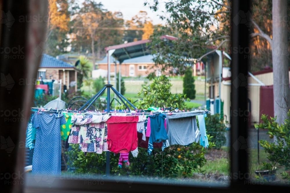 Looking through a window at clothes hanging on a washing line - Australian Stock Image