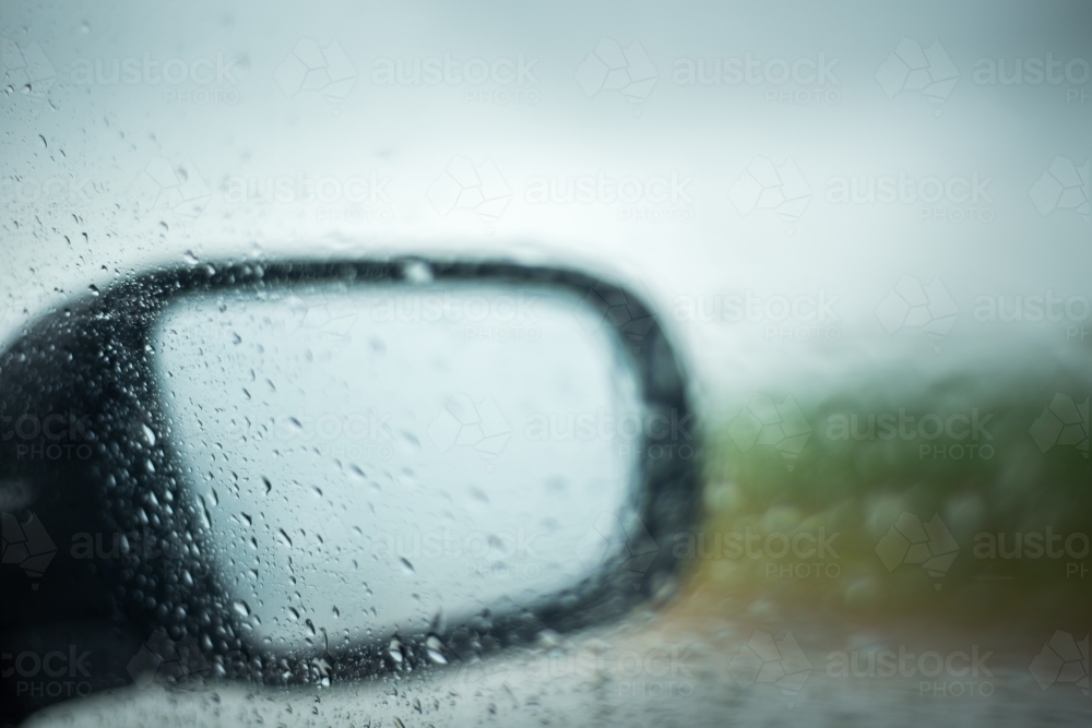 Looking through car window at side mirror in the rain - Australian Stock Image