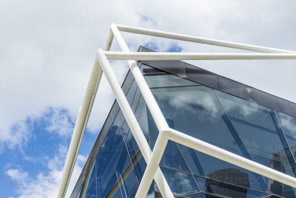 Looking up at a modern metal framework around a glass sided building - Australian Stock Image