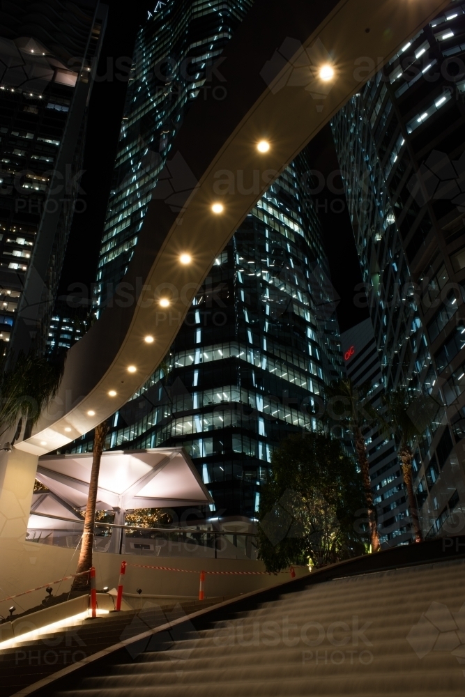 Looking up at night scene of high rise buildings and city lights - Australian Stock Image