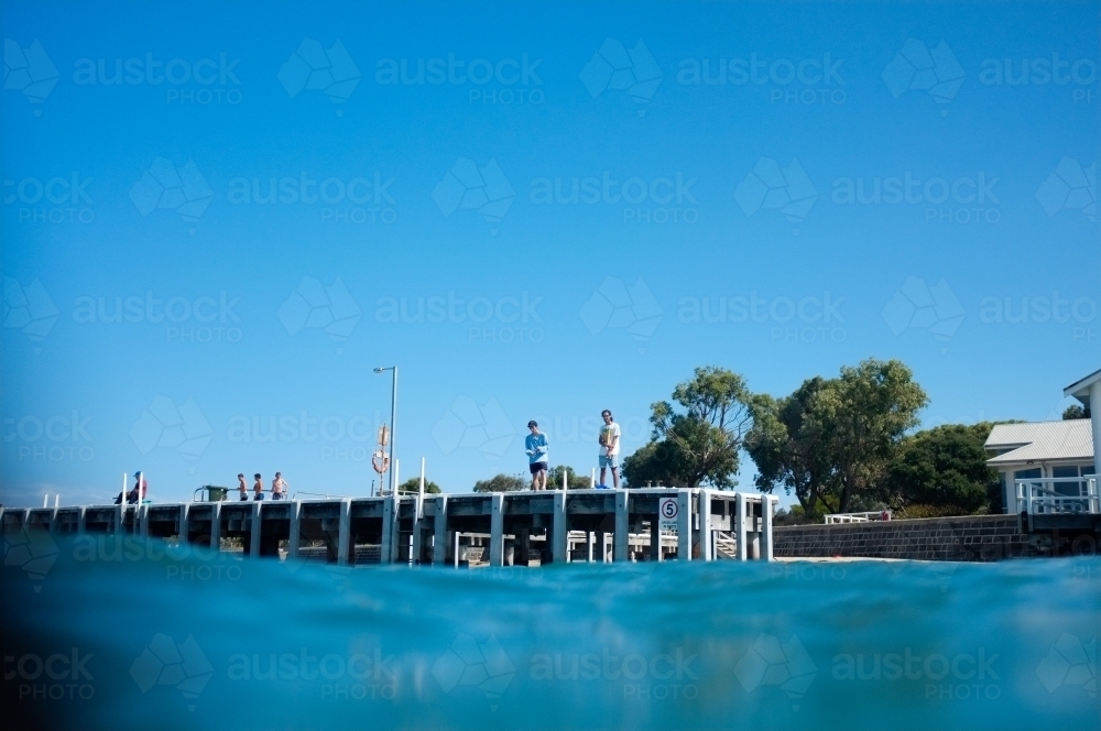 Looking up at people on a wharf - Australian Stock Image