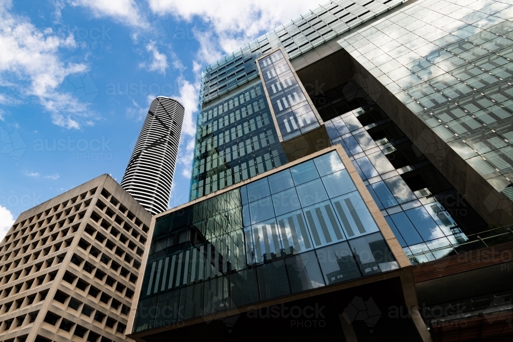 Looking up at skyscrapers and blue sky with clouds - Australian Stock Image
