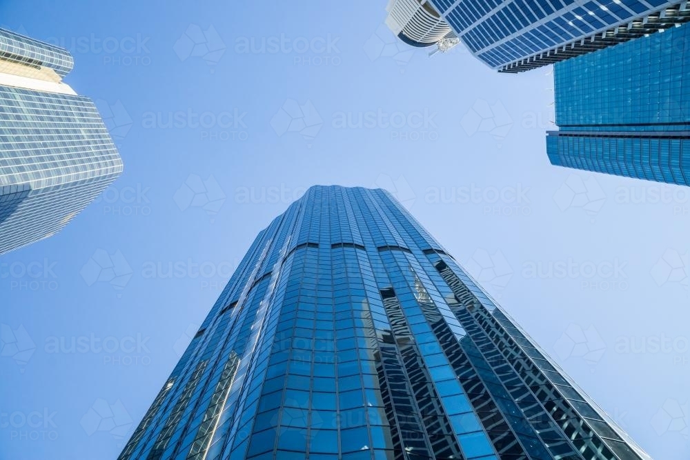 Looking up at three skyscrapers converging overhead - Australian Stock Image