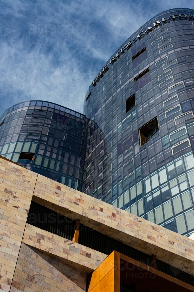 Looking up at unusual and patterned shapes of high rise buildings with dark blue sky - Australian Stock Image
