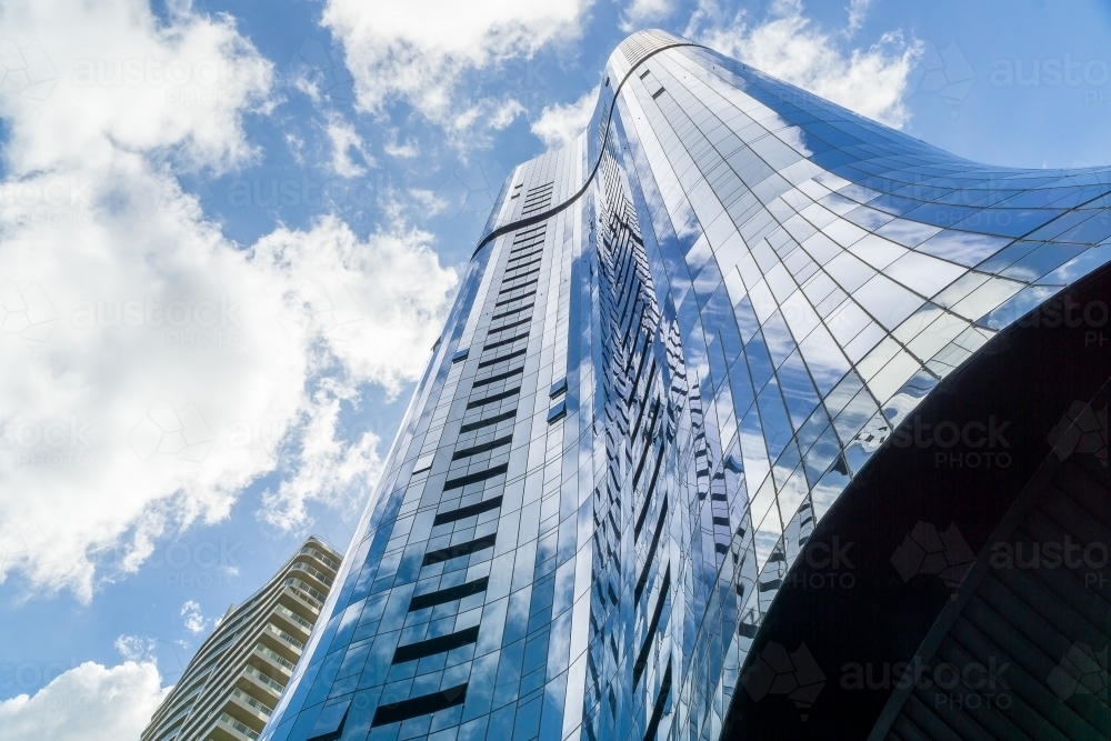 Looking up the side of a glass covered skyscraper - Australian Stock Image