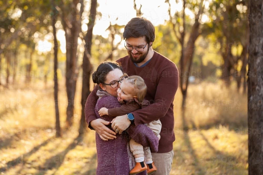Image of Loving family hug - mum and dad cuddling one year old toddler ...