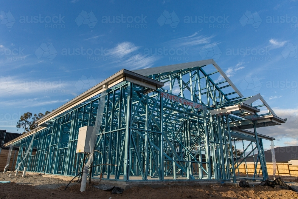 low angle shot of a house at frame stage under construction under a blue sky - Australian Stock Image